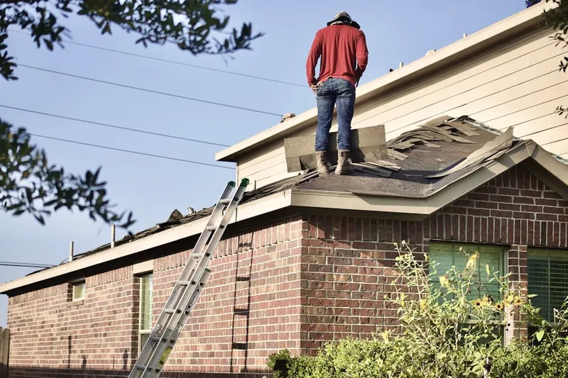 Professional roofer working on a residential roof in Med Center